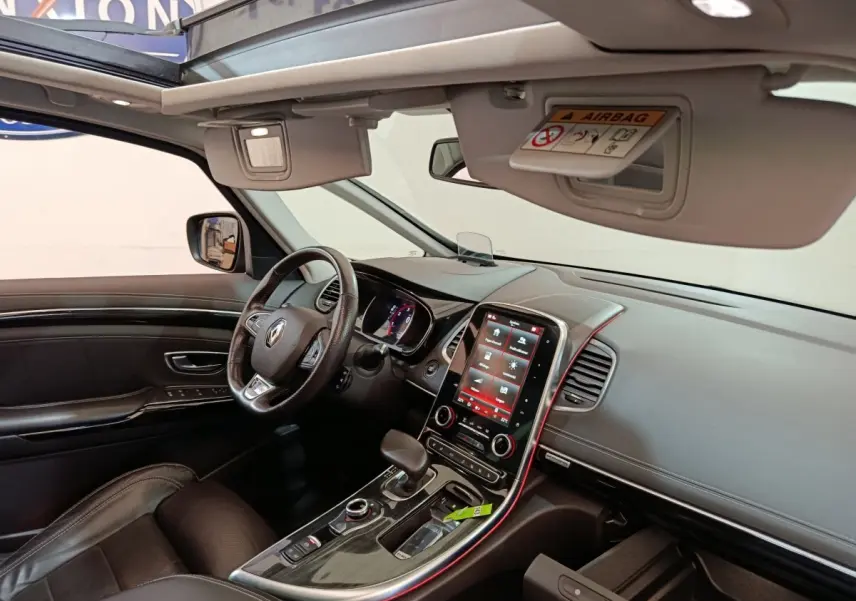 Vue intérieure côté conducteur du Renault Espace noir 2018, tableau de bord moderne avec écran tactile vertical et toit ouvrant panoramique.