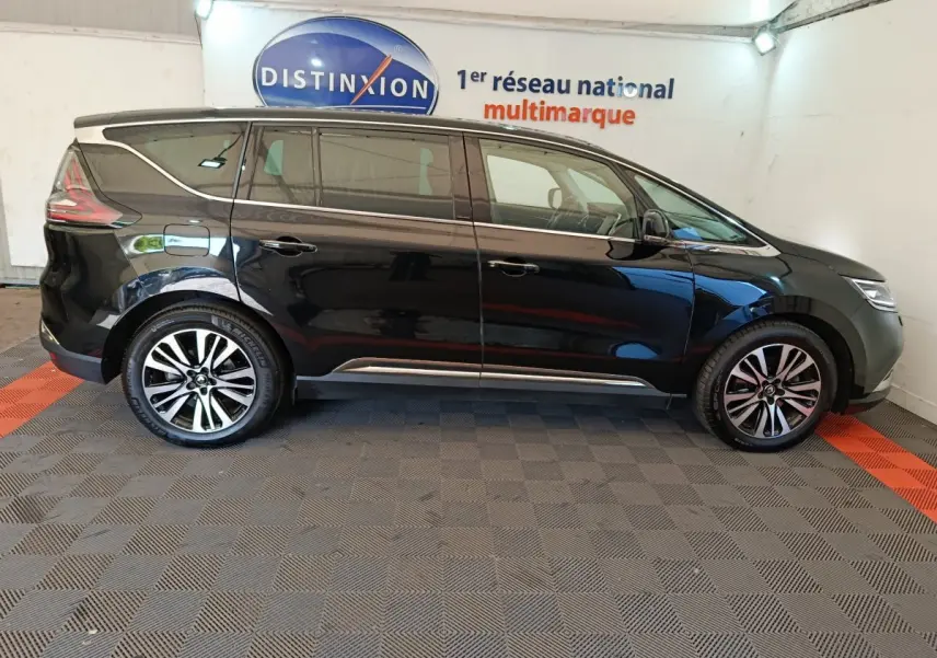 Profil côté gauche d'un Renault Espace noir 2018 garé en intérieur avec jantes alliage bicolores et vitres teintées.