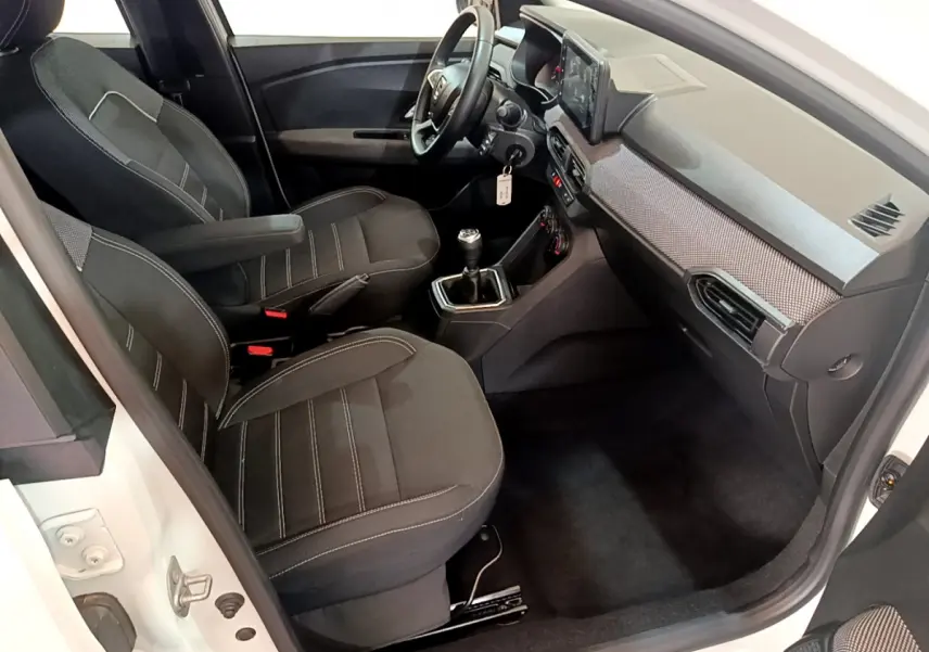 Intérieur avant droit de la Dacia Sandero Confort TCe 90 2022 avec sièges noirs et tableau de bord moderne.