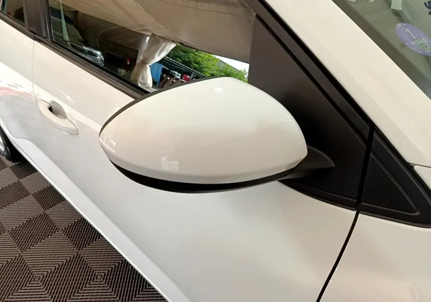 Rétroviseur blanc côté gauche d'une Dacia Sandero Confort TCe 90 2022, avec poignée de porte visible en arrière-plan.