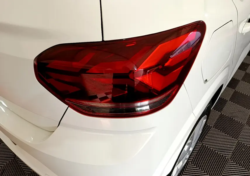 Gros plan sur le feu arrière droit rouge d'une DACIA SANDERO Confort blanche, vue arrière côté droit.