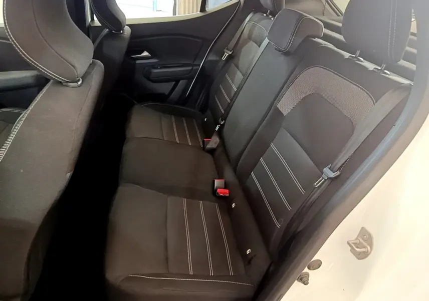 Vue intérieure côté droit des sièges arrière noirs avec surpiqûres blanches d'une Dacia Sandero blanche 2022 Confort TCe 90.