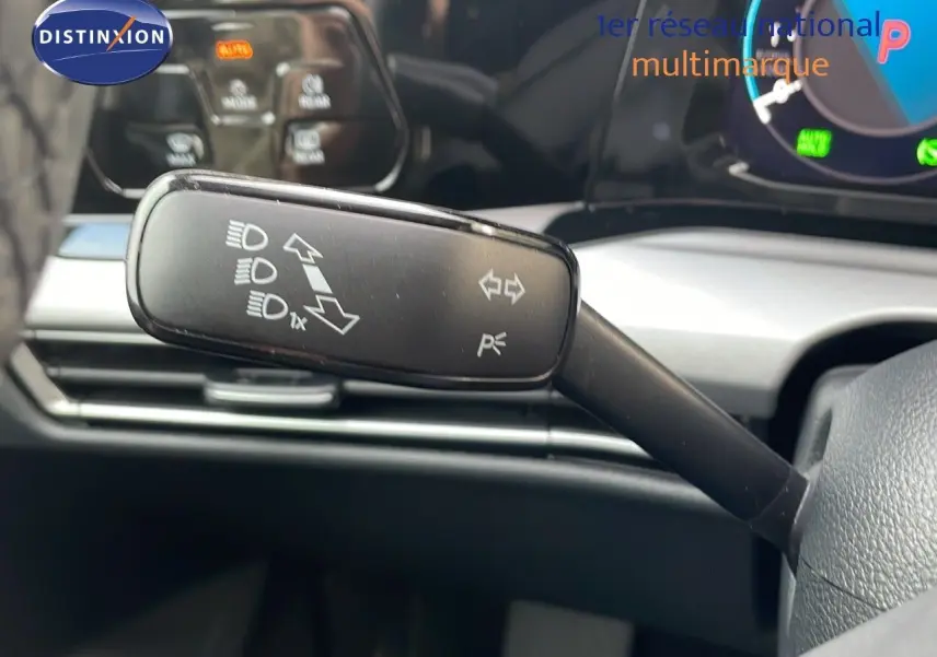 Le levier de clignotant noir de la Volkswagen Golf VIII visible côté gauche du volant, avec tableau de bord numérique en arrière-plan.