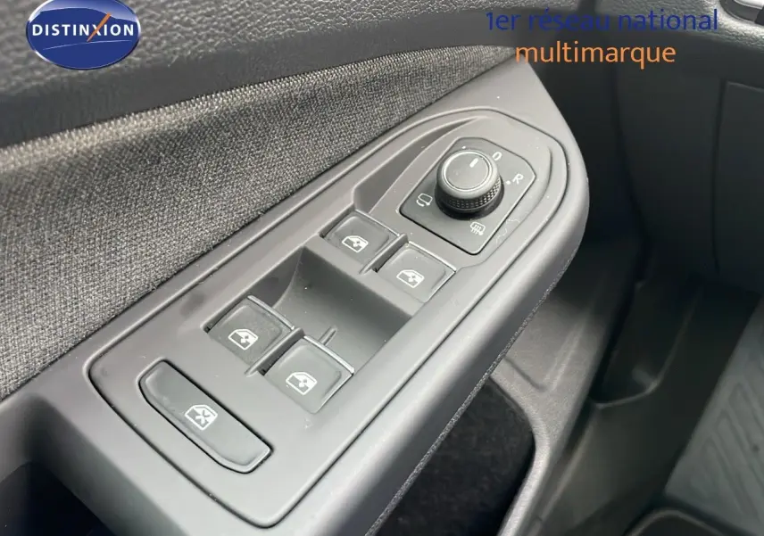 Gros plan sur la commande des vitres électriques côté gauche d'une Volkswagen Golf VIII bleu lapiz metal, intérieur tissu gris.