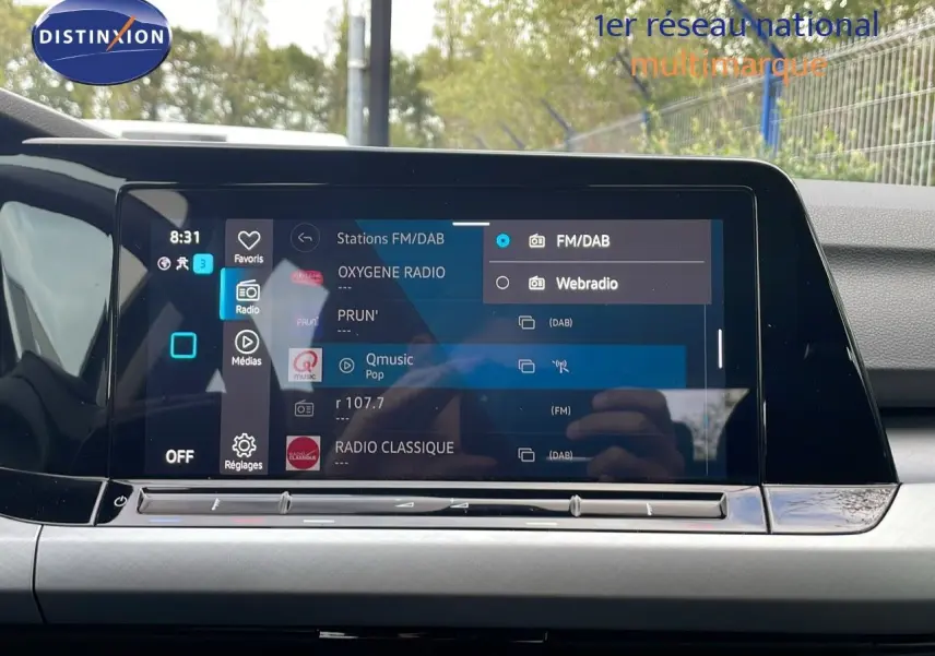 Vue intérieure centrée sur l'écran tactile multimédia de la Volkswagen Golf VIII 2023 avec interface radio FM/DAB affichée.
