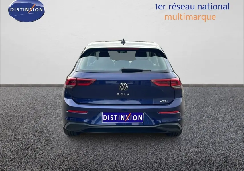 Vue arrière d'une Volkswagen Golf VIII bleu lapiz metal avec feux LED et logo distinctif au centre du hayon.