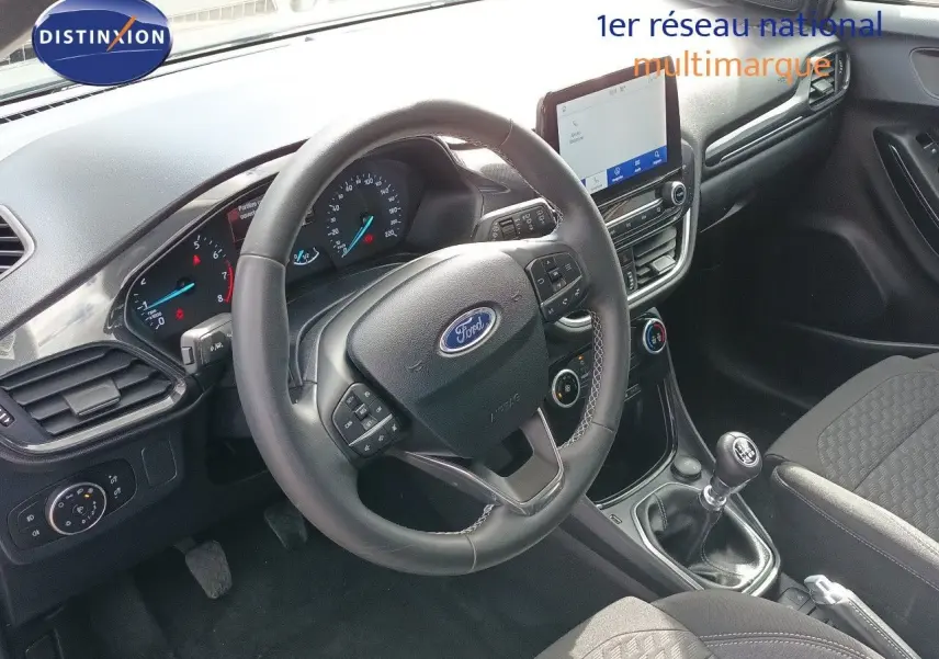 Vue intérieure côté conducteur du Ford Puma 2023 gris foncé, volant multifonction et levier de vitesse manuel visibles.