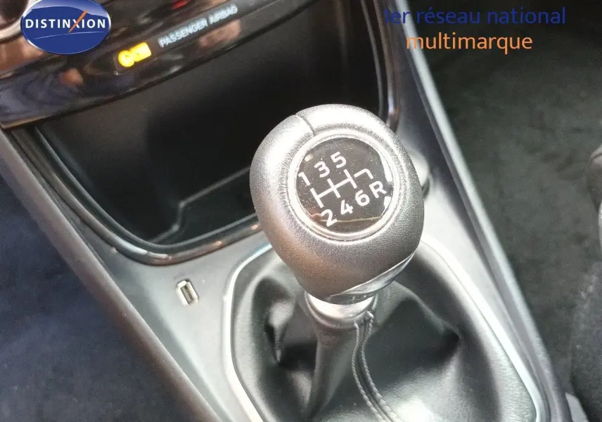 Gros plan sur le levier de vitesses manuel noir de la Ford Puma gris foncé, avec indication des six rapports et marche arrière.