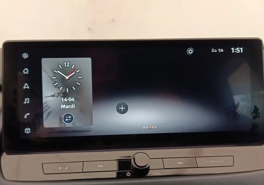Écran tactile central du Nissan Qashqai 2023 affichant une horloge digitale, boutons de contrôle en dessous.