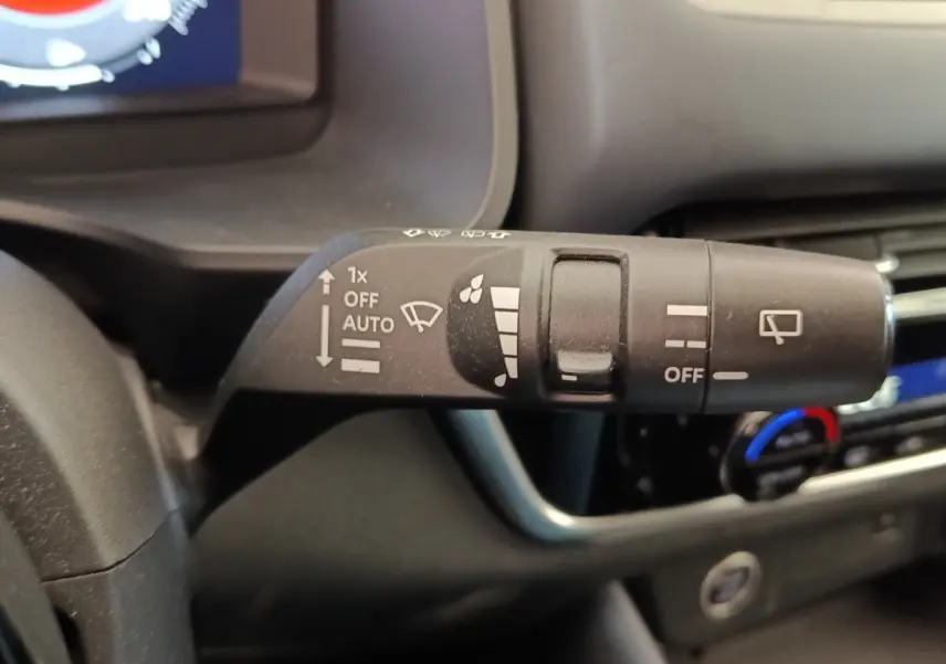 Gros plan sur la commande d’essuie-glace du Nissan Qashqai 2023, intérieur noir avec tableau de bord visible.