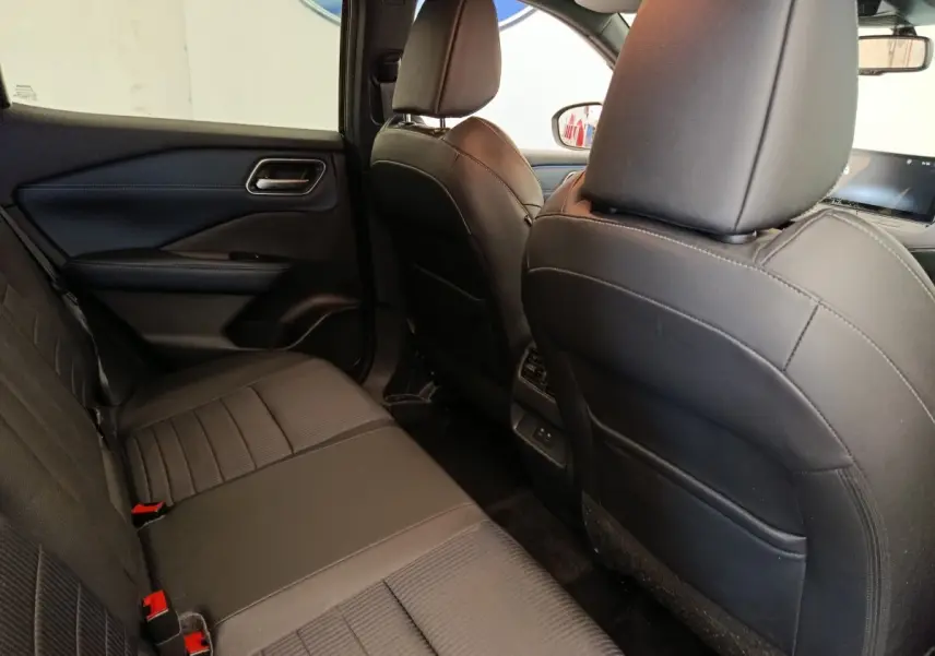 Vue intérieure arrière côté gauche du Nissan Qashqai noir 2023, montrant les sièges en cuir et la console centrale.