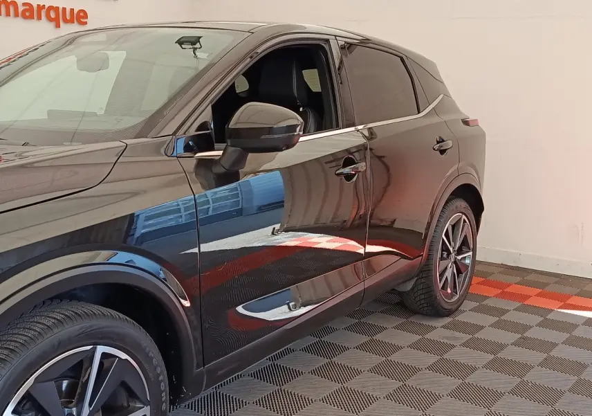 Vue de côté droit du Nissan Qashqai noir 2023, mettant en valeur les jantes alliage et les vitres teintées.