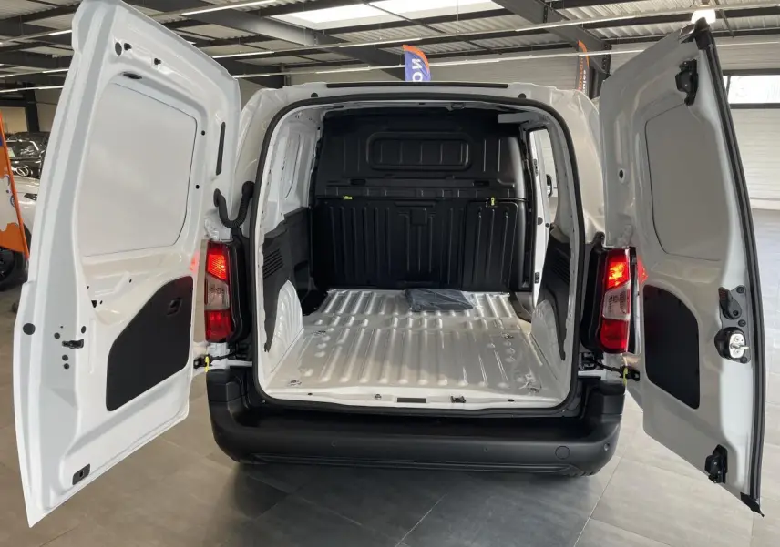 Vue arrière du Peugeot Partner blanc 2026 avec portes battantes ouvertes montrant l'espace de chargement vide et tôlé.