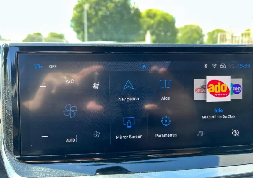 Écran tactile du tableau de bord du Peugeot 2008 Hybrid noir, affichant navigation et radio Ado.