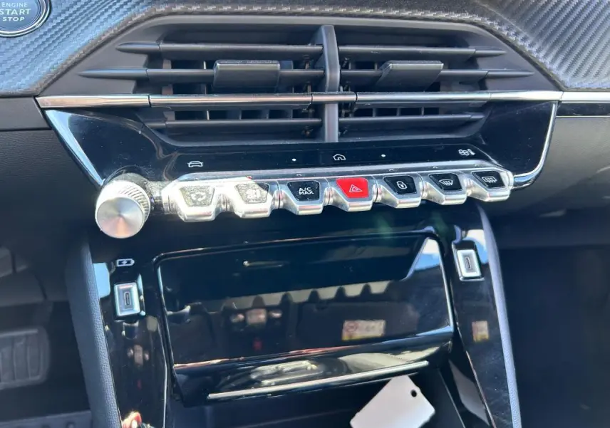 Vue rapprochée du tableau de bord noir du Peugeot 2008 Hybrid 136 e-DCS6 Allure avec commandes tactiles et bouton start/stop.