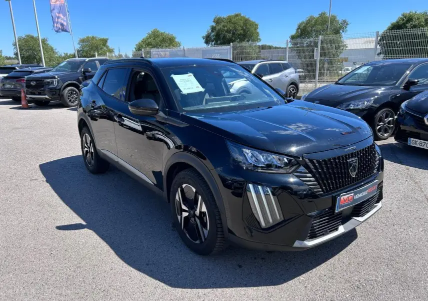 Peugeot 2008 Hybrid noir en 3/4 avant droit, avec barres de toit et jantes alliage 17 pouces visibles.