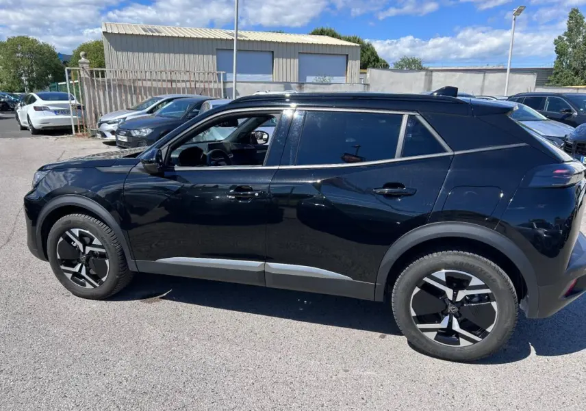 Peugeot 2008 Hybrid noir vue de profil côté gauche, avec barres de toit et jantes alliage 17 pouces.