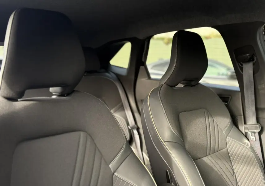 Vue intérieure sur les sièges avant en tissu noir avec surpiqûres contrastantes du Renault Symbioz 2025.