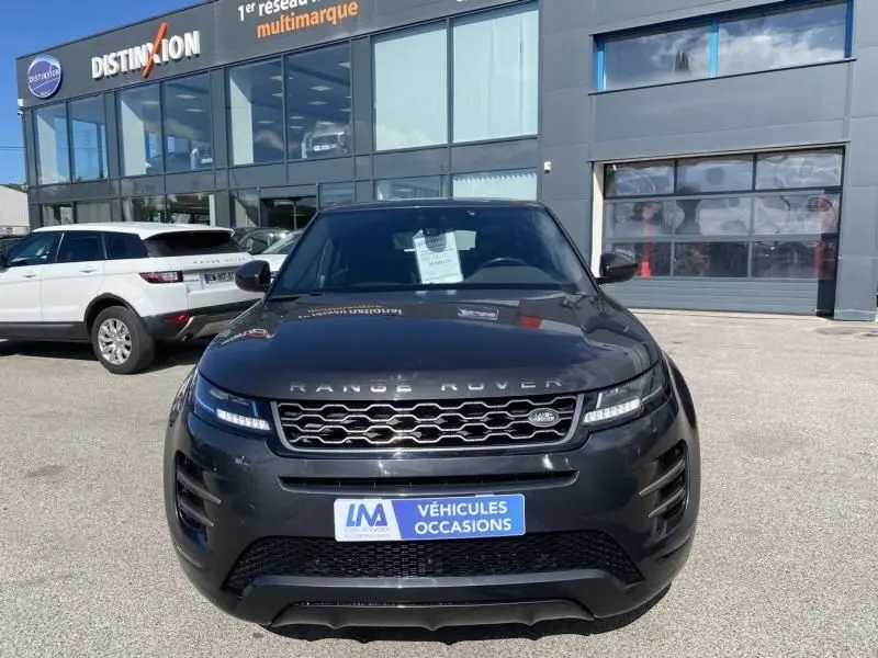 Vue frontale d'un Range Rover Evoque gris foncé métal 2019 avec calandre hexagonale et feux LED allumés.