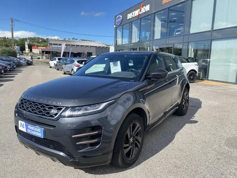 Vue 3/4 avant droit d'un Range Rover Evoque 2019 gris foncé métallisé devant un concessionnaire.
