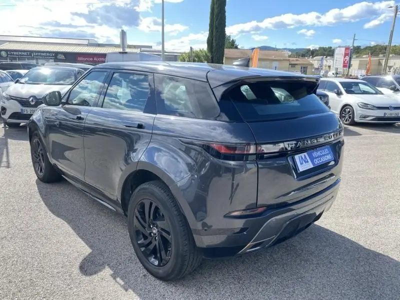 Vue 3/4 arrière droite d'un Range Rover Evoque gris foncé métal 2019 avec jantes noires, stationné en extérieur.
