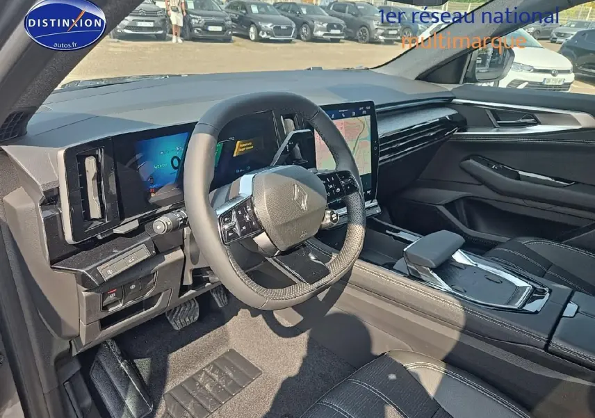 Intérieur du Renault Austral 2025, vue côté conducteur, volant multifonction et écran tactile central visibles.