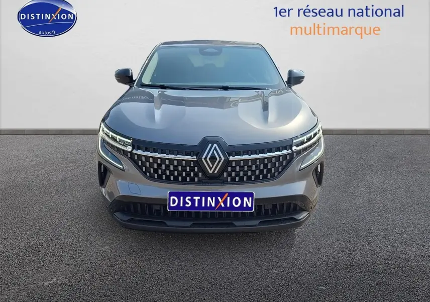 Renault Austral gris schiste vu de face, avec calandre moderne et phares LED distinctifs allumés.