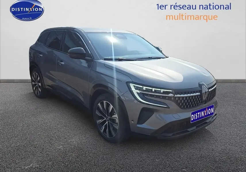 Renault Austral gris schiste en 3/4 avant droit avec jantes alu et phares LED allumés sur fond neutre.