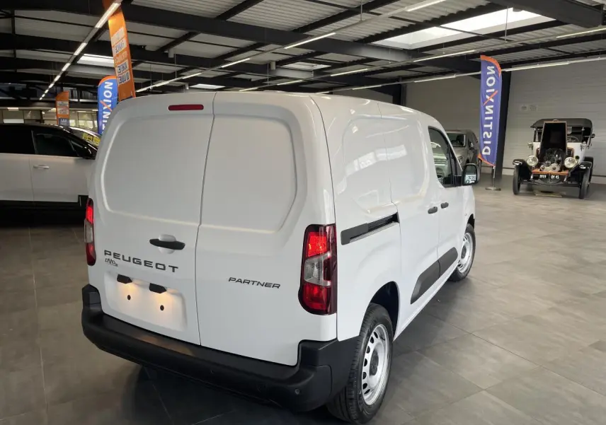 Vue 3/4 arrière droite du Peugeot Partner blanc utilitaire avec portes arrière battantes et jantes tôles grises.