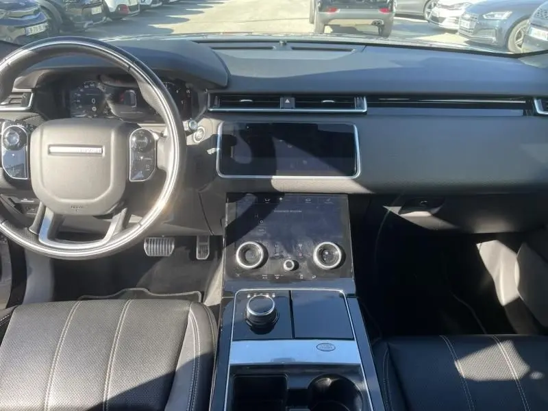 Intérieur du Range Rover Velar 2020 gris métal, vue de dessus du poste de conduite avec tableau de bord et console centrale moderne.