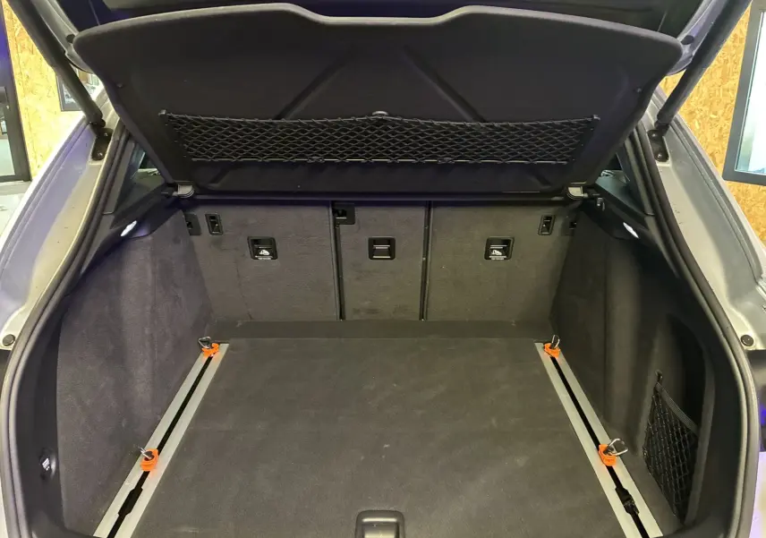 Coffre ouvert noir du Porsche Macan 3.0 360 GTS 2017, montrant l'espace de rangement et filets latéraux.