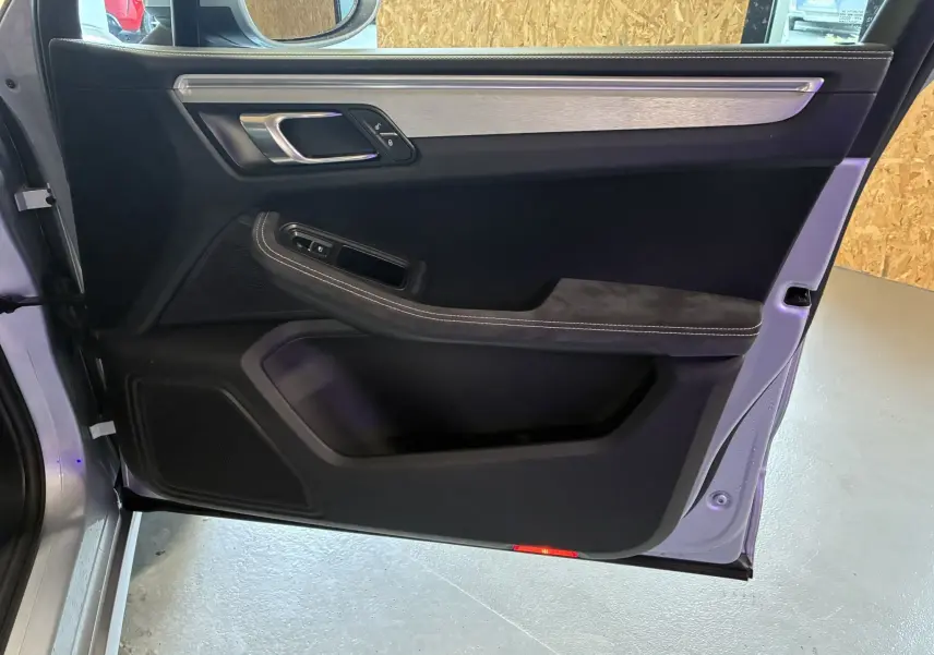 Vue côté gauche de la porte avant noire du Porsche Macan GTS 2017 avec insert aluminium brossé et commandes intégrées