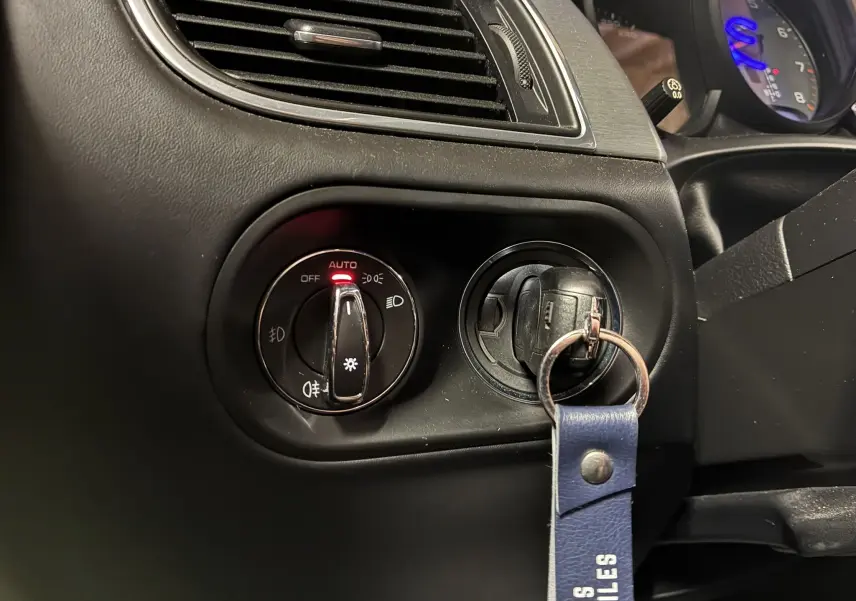 Gros plan sur la commande d'éclairage et la clé insérée dans le contact d'un Porsche Macan GTS 2017, intérieur noir.