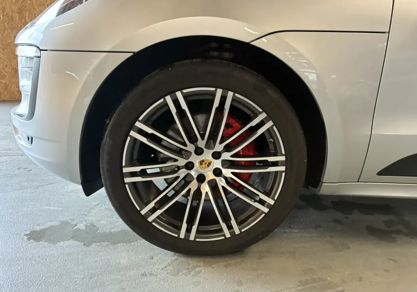 Gros plan sur la roue avant gauche argentée du Porsche Macan 3.0 360 GTS avec étrier de frein rouge visible.
