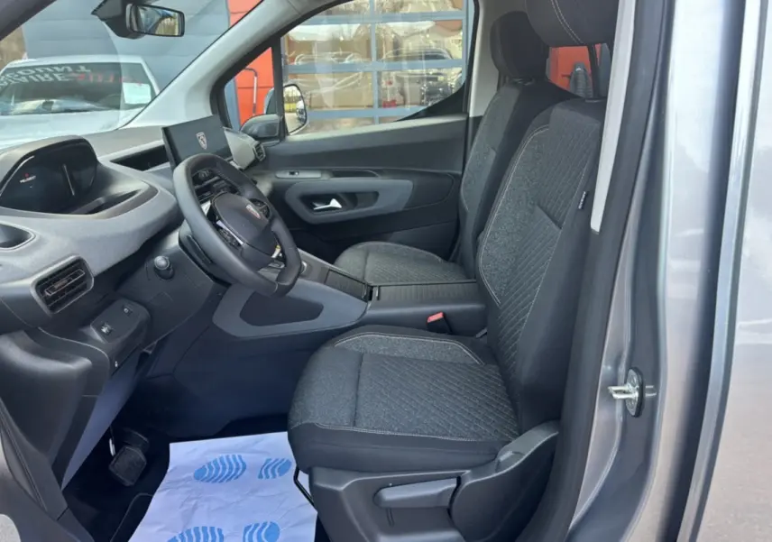 Intérieur avant du Peugeot Rifter gris artense 2026, vue côté gauche montrant sièges tissu et tableau de bord moderne.
