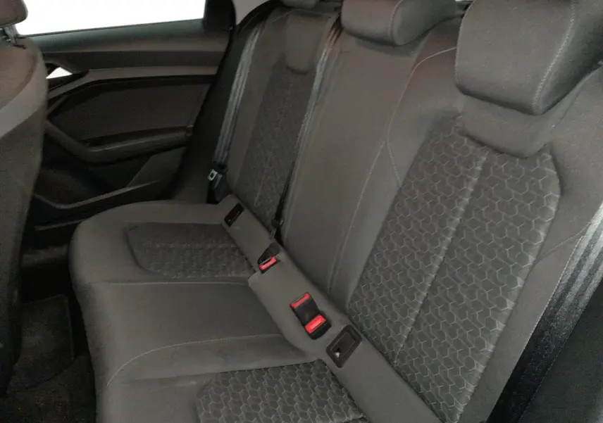 Vue latérale gauche de la banquette arrière noire de l'Audi A1 Sportback 2023 avec sièges sport et ceintures visibles.