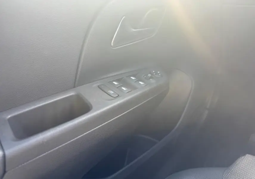Détail de la porte côté conducteur de l’Opel Corsa noire 2025 avec commandes des vitres et rétroviseurs électriques.