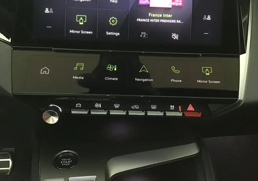 Vue rapprochée de la console centrale de la Peugeot 308 2025 avec écran tactile et commandes tactiles rétroéclairées.