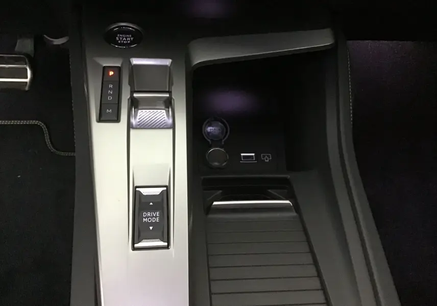 Vue rapprochée de la console centrale grise avec levier de vitesses et bouton Drive Mode d'une Peugeot 308 blanche 2025.