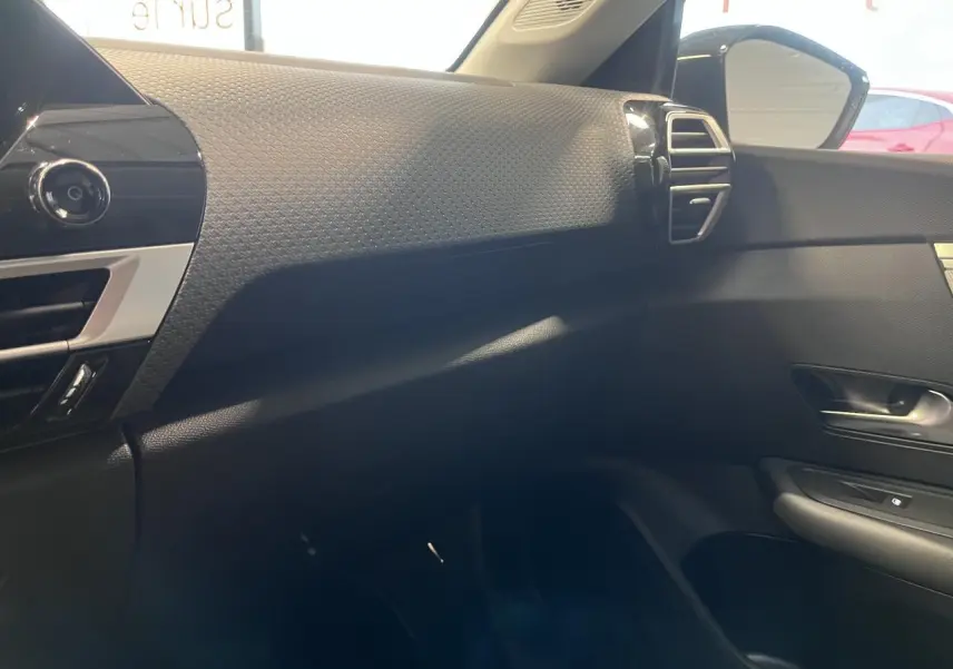 Vue intérieure côté passager de la planche de bord noire texturée avec aérateur argenté d'une Citroën C4 2025.