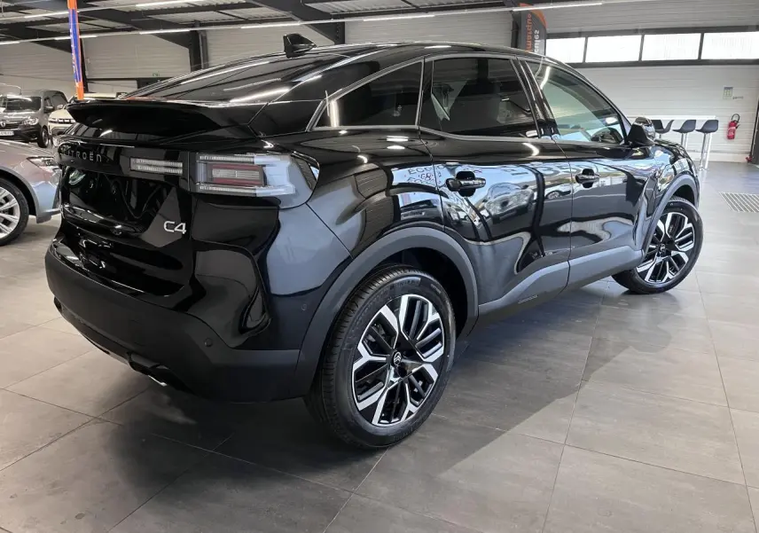 Vue 3/4 arrière droite d'une Citroën C4 noire métallisée avec jantes alliage 18'' et feux LED distinctifs.