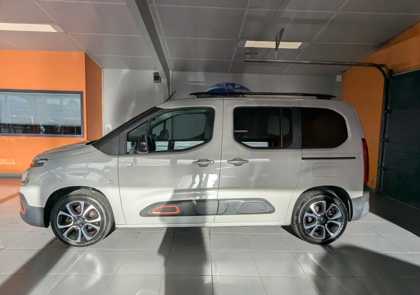 Vue de profil côté gauche d'un Citroën Berlingo beige 2019 avec jantes bi-ton et détails orange sur les protections latérales.