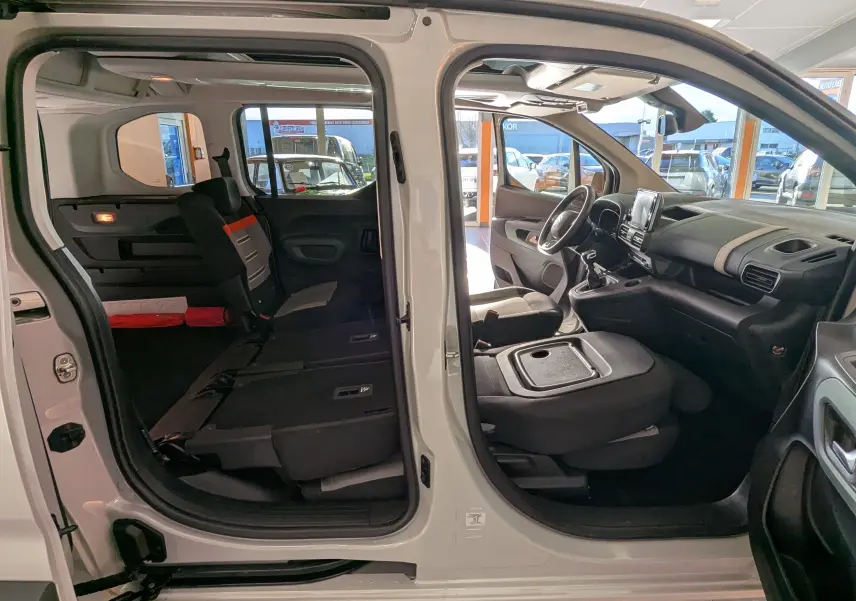 Vue latérale gauche intérieure du Citroën Berlingo beige 2019 avec portes ouvertes et sièges arrière rabattus.