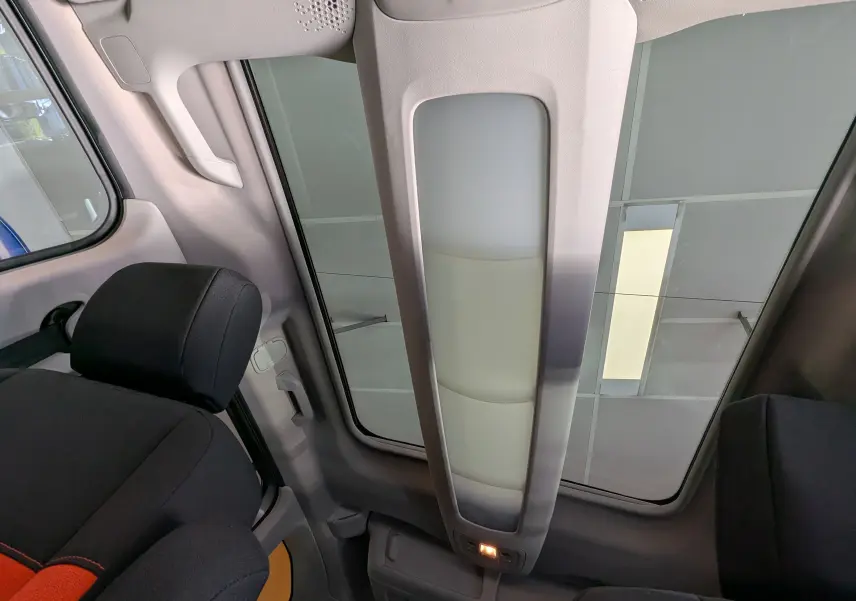 Vue intérieure du toit panoramique et des sièges noirs avec surpiqûres rouges du Citroën Berlingo beige 2019.