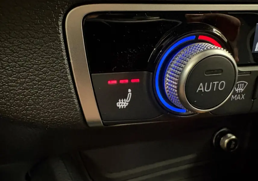 Gros plan sur la commande de siège chauffant et régulation automatique de la climatisation dans l'Audi Q2 Gris Daytona.