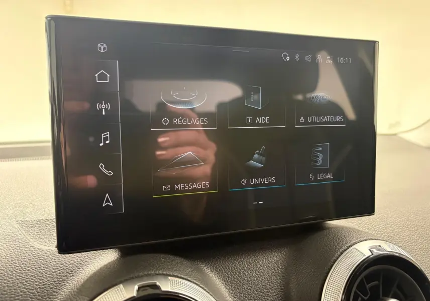Vue intérieure du tableau de bord de l'Audi Q2 35 TFSI S Line 2026 avec écran tactile central et aérateurs ronds.