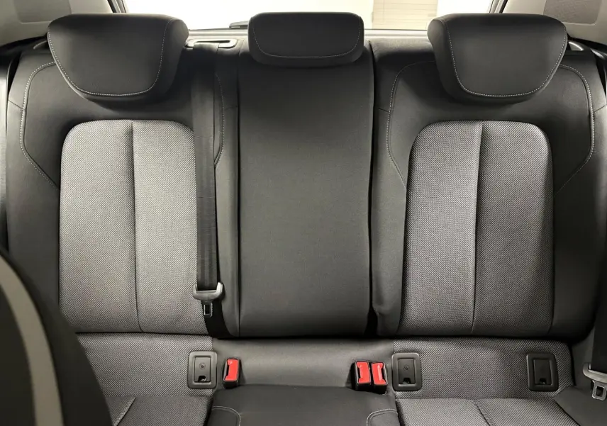 Vue arrière intérieure des sièges arrière noirs de l'Audi Q2 35 TFSI S Line 2026 avec appuie-têtes et ceintures visibles.