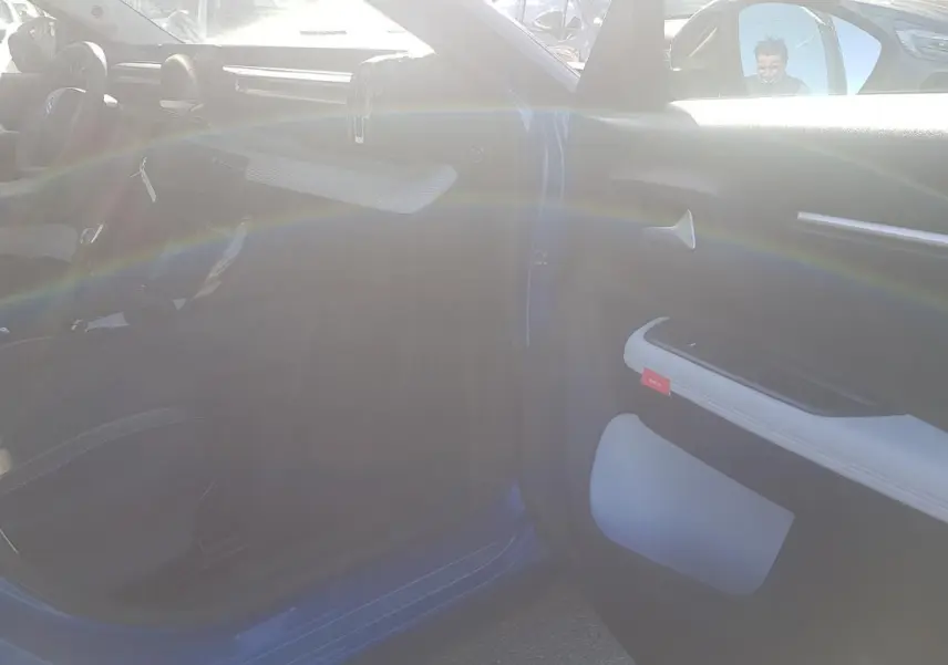 Vue intérieure côté passager d'une Citroën C3 bleu foncé 2024 avec détails du panneau de porte clair et volant visible.