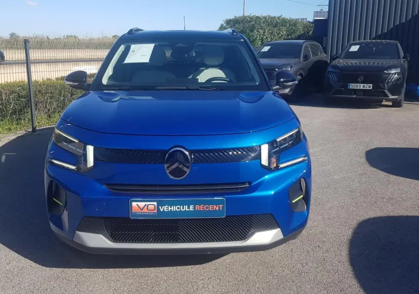 Vue frontale d'une Citroën C3 bleu foncé 2024 avec barres de toit et calandre noire distinctive.