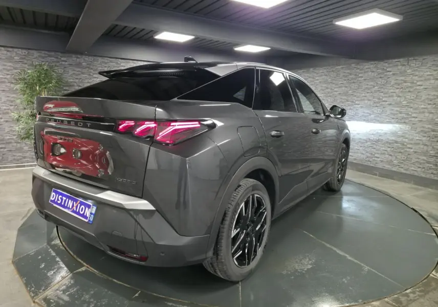 Vue 3/4 arrière droite d’un Peugeot 3008 gris métallisé avec feux arrière à griffes LED et jantes alliage noires.